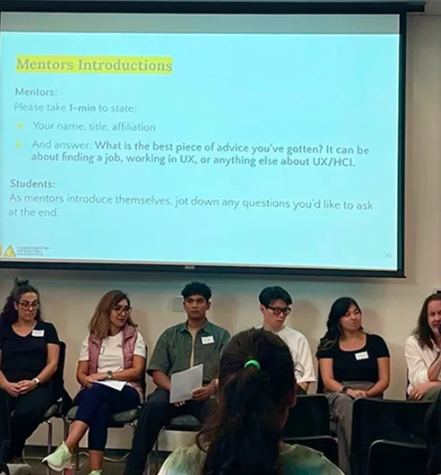 A row of mentors facing an audience under a slide titled "Mentors Introductions".