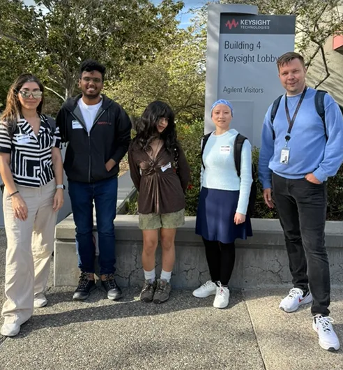 A group of students and mentors outside the Keysight Building 4 lobby.